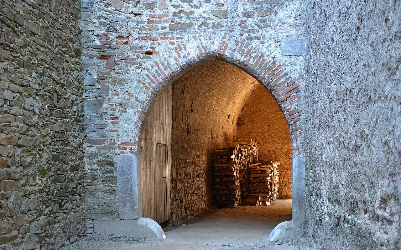 Das Tor am fünften Hof von Pernštejn, massives gotisches Mauerwerk, das den Durchgang rahmt